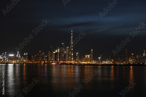 Night view of Dubai Skyline under Cloudy Sky, Dubai Downtown Residential and Business Skyscrapers, a view from Dubai Water Canal, Dubai, United Arab Emirates