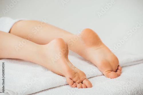 selective focus of adult woman lying on beige towel in spa