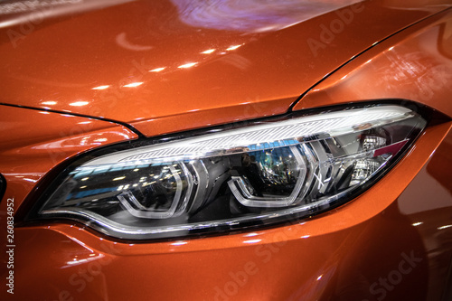 Headlight of orange modern car with LED light