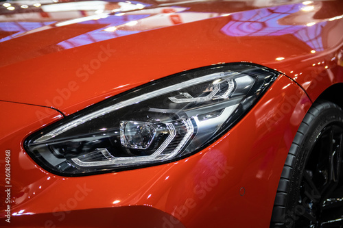 Headlight of orange modern car with LED light