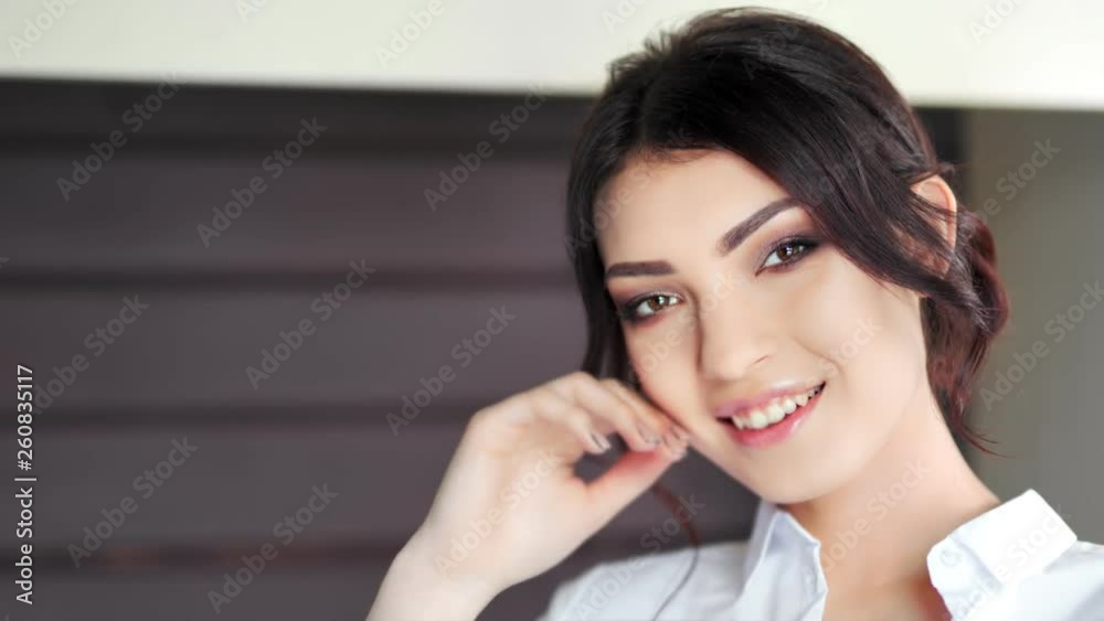 Portrait of beautiful sexy Caucasian girl with perfect makeup smiling and looking at camera closeup Portrait of beautiful sexy Caucasian girl with perfect makeup smiling and looking at camera closeup