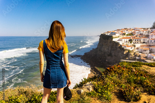 Young woman from back looking to Azenhas do Mar, near Sintra, Portugal.