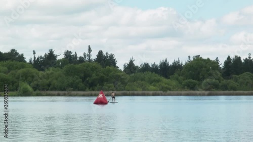 Male Kayaking on Calm Water Behind Bouy in Laguna Avendano Quillon Chile on Cloudy Day photo