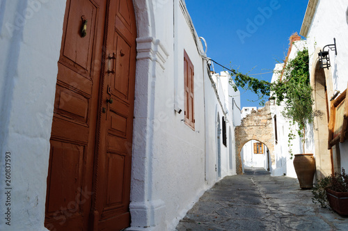 Narrow streets with white houses of Lindos, Greece. © delobol
