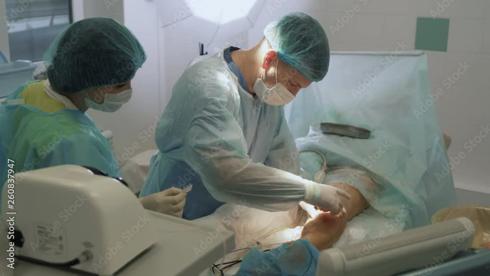 Surgeon treats wounds and bandages patient leg after sclerotherapy operation Surgeon treats wounds and bandages patient leg after sclerotherapy operation