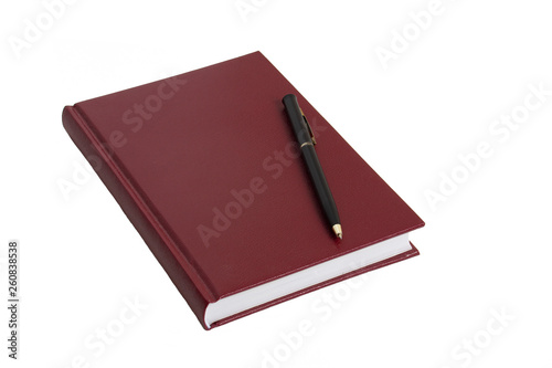 The burgundy notebook and black pen lie on a white table.