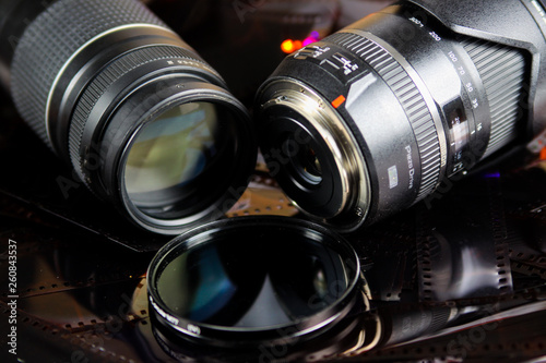 Close up of two camera lenses with isolated circular filter on negative film strips