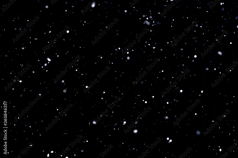 Falling snow on black background Snowflakes Flying in the air.