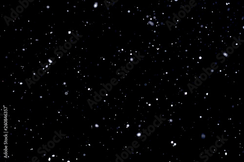Falling snow on black background Snowflakes Flying in the air.