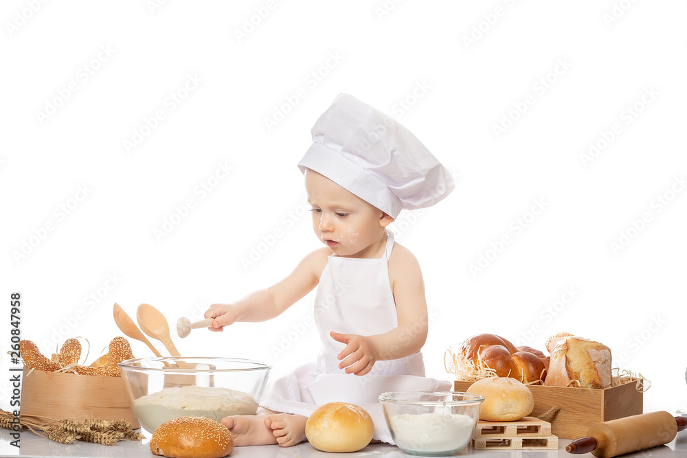 Happy smiling boy chef white uniform isolated on white background. Portrait image. Cooking child lifestyle concept. Toddler playing Happy smiling boy chef white uniform isolated on white background. Portrait image. Cooking child lifestyle concept. Toddler playing