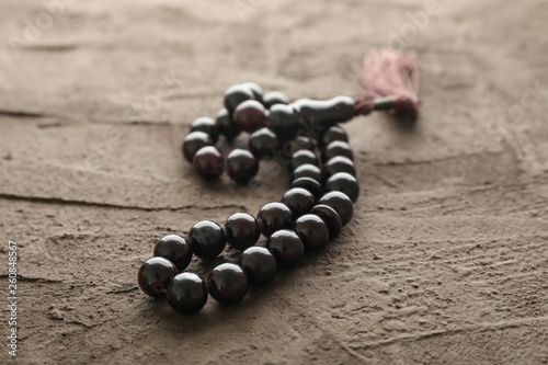 Prayer beads on brown background, space for text