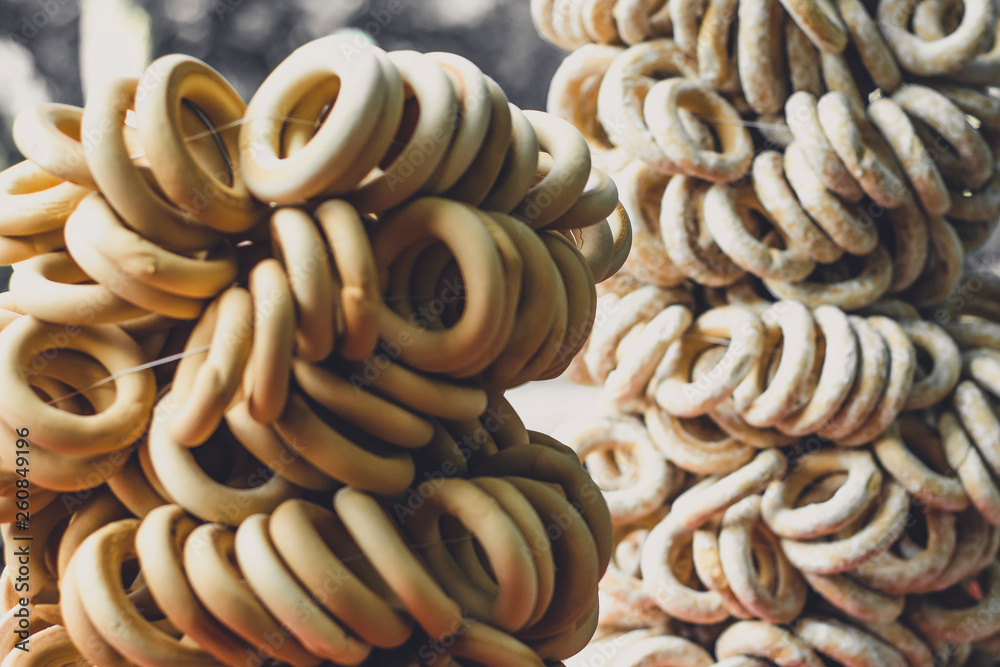 many bagels wrapped in a tie at a street food festival, knitting bagels with poppy seeds many bagels wrapped in a tie at a street food festival, knitting bagels with poppy seeds
