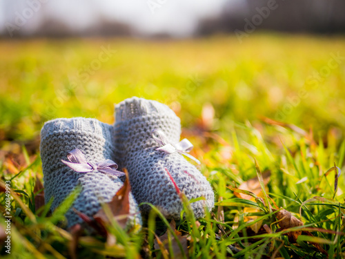 Two newborn shoes on the grass with ties