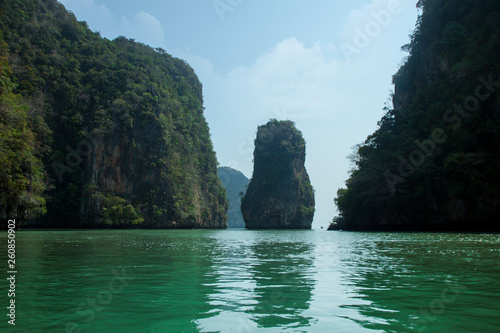 Beautiful view of the islands and ocean. Green sheer cliffs cover tropic plants. Archipelago in Andaman Sea, Thailand.