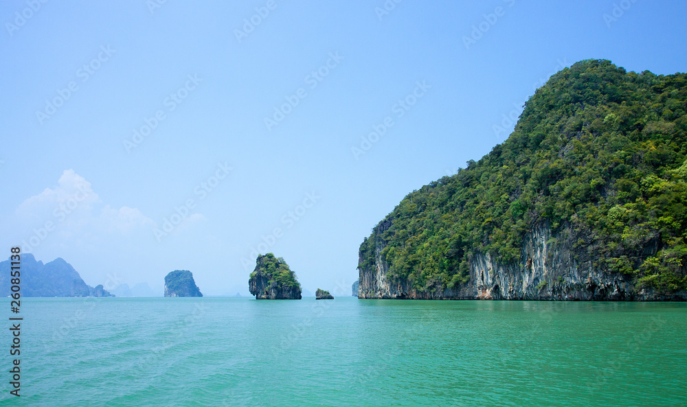 Obraz premium Beautiful view of the islands and ocean. Green sheer cliffs cover tropic plants. Archipelago in Andaman Sea, Thailand.