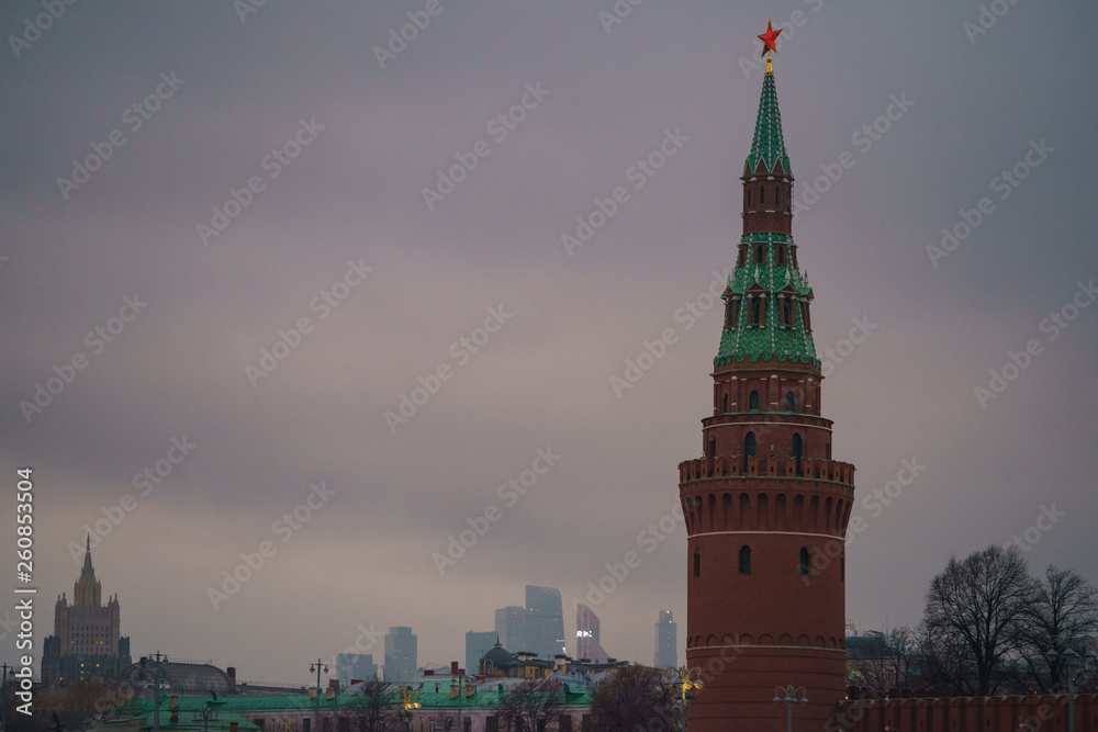 Red Moscow Kremlin Towers at the overcast day. MIBC (Moscow International Business Center) and Ministry of Foreign Affairs as background.