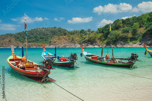 Beautiful exotic boats in lagoon. Seascape with transparent azure water and coast with tropical forest. Thailand. Andaman Sea. 