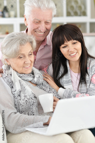 Portrait of happy family with laptop at home