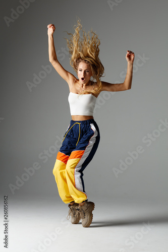 Fototapeta Naklejka Na Ścianę i Meble -  Hip hop dancer moving and jumping in photostudio