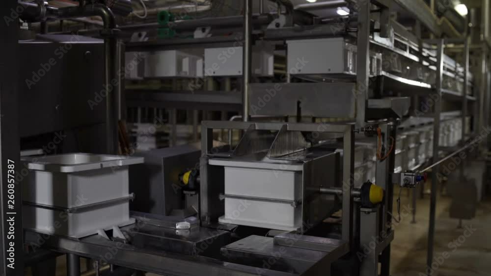 Milk making factory process. Cheese covering in steel cases with holes before square curd pressing. Milk making factory process. Cheese covering in steel cases with holes before square curd pressing.