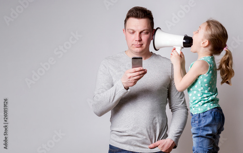 Father using smartphone ignoring his daughter photo
