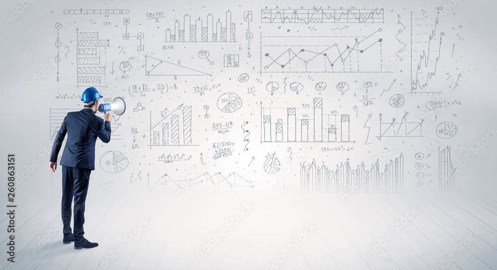 Engineer with construction helmet holding a plan and standing with graphs, charts and reports on the background Engineer with construction helmet holding a plan and standing with graphs, charts and reports on the background