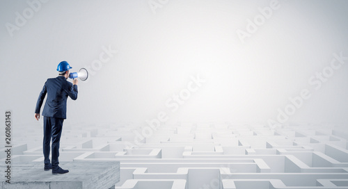 Architect standing on maze and looking at a future plan
