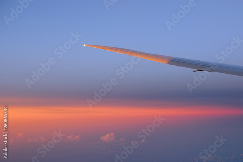 wing aircraft in the sky with clouds at sunset