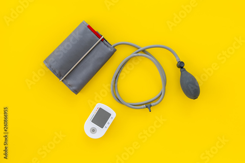pulsimeter on the desk of the doctor for diagnostics of cardiac disease on yellow background top view