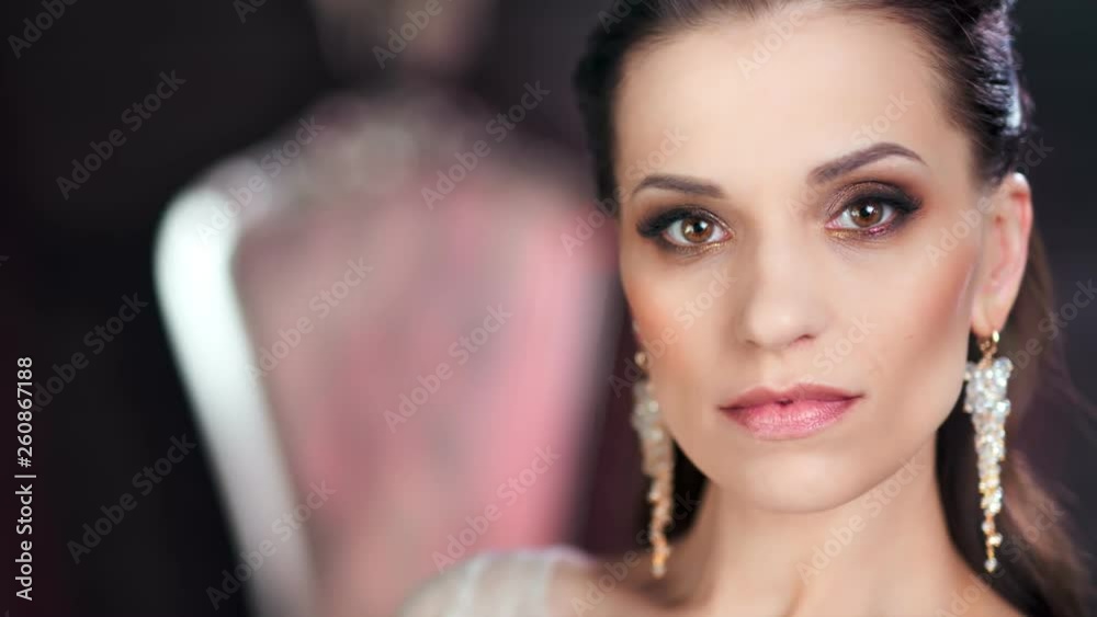 Close-up confident face of beautiful European woman with amazing evening makeup and perfect skin Close-up confident face of beautiful European woman with amazing evening makeup and perfect skin