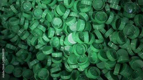 Green plastic bottle caps. Plastic waste. Packaging equipment at dairy factory photo