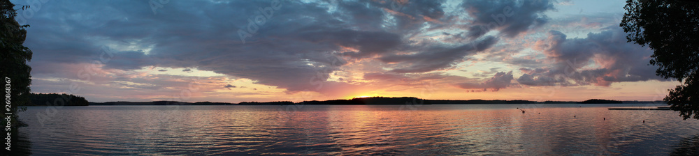 Sunset on the lake horizon landscape. Dark sunset over river water view panoramic.
