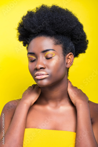 beautiful african american woman with closed eyes isolated on yellow