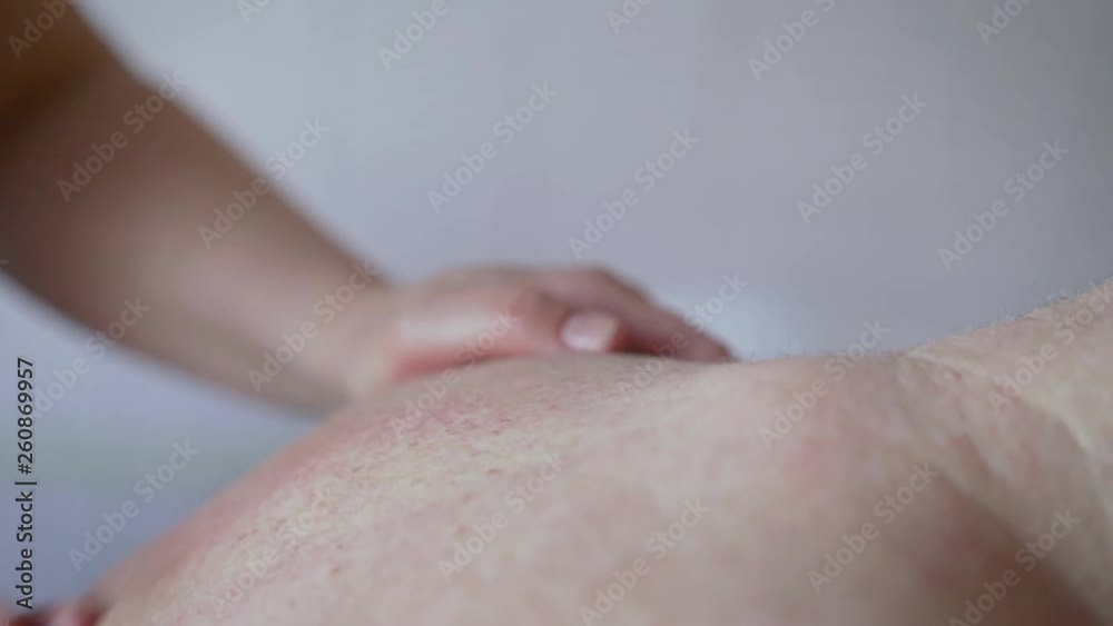 Sports massage - Lower back massage - Physical therapist doing massage of lower back. Toned image, selective focus. Female hands doing massage to an old man. Sports massage - Lower back massage - Physical therapist doing massage of lower back. Toned image, selective focus. Female hands doing massage to an old man.