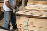 Close up on the worker holding building material planks loading at the warehouse for the construction site
