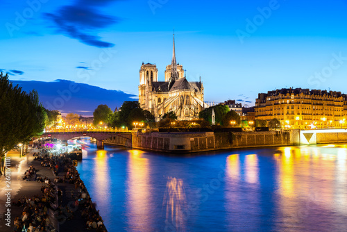 Notre Dame De Paris at night and the seine river in Paris, France.