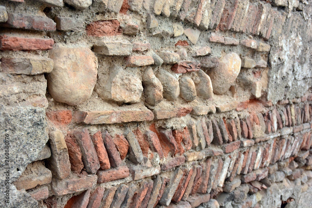 Muro histórico hecho con ladrillos y piedras