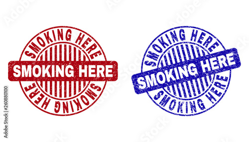 Grunge SMOKING HERE round stamp seals isolated on a white background. Round seals with distress texture in red and blue colors.