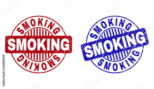 Grunge SMOKING round stamp seals isolated on a white background. Round seals with grunge texture in red and blue colors. Vector rubber imitation of SMOKING caption inside circle form with stripes.