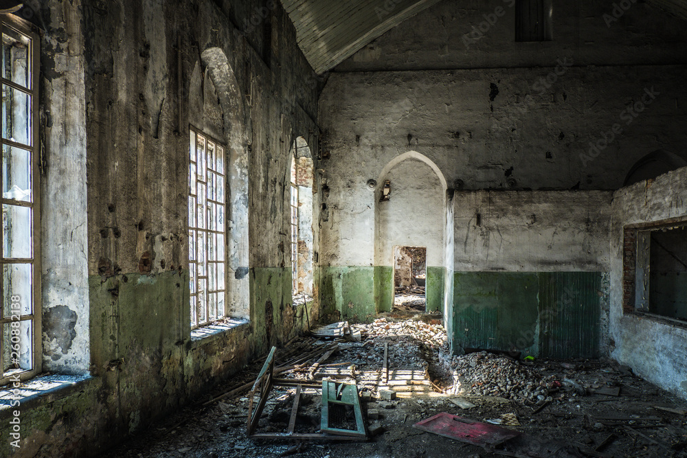 Old abandoned industrial building with broken lancet windows inside 