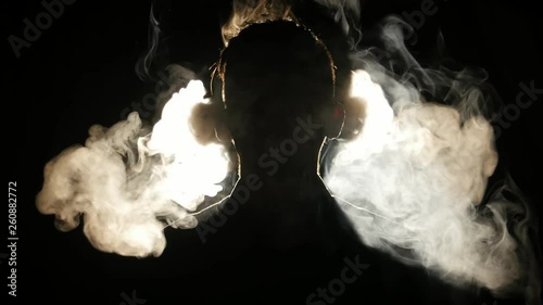 Silhouette of young boy smoking electronic cigarette in the darkness. 