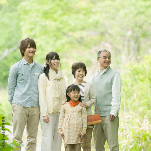 新緑の中で微笑む3世代家族