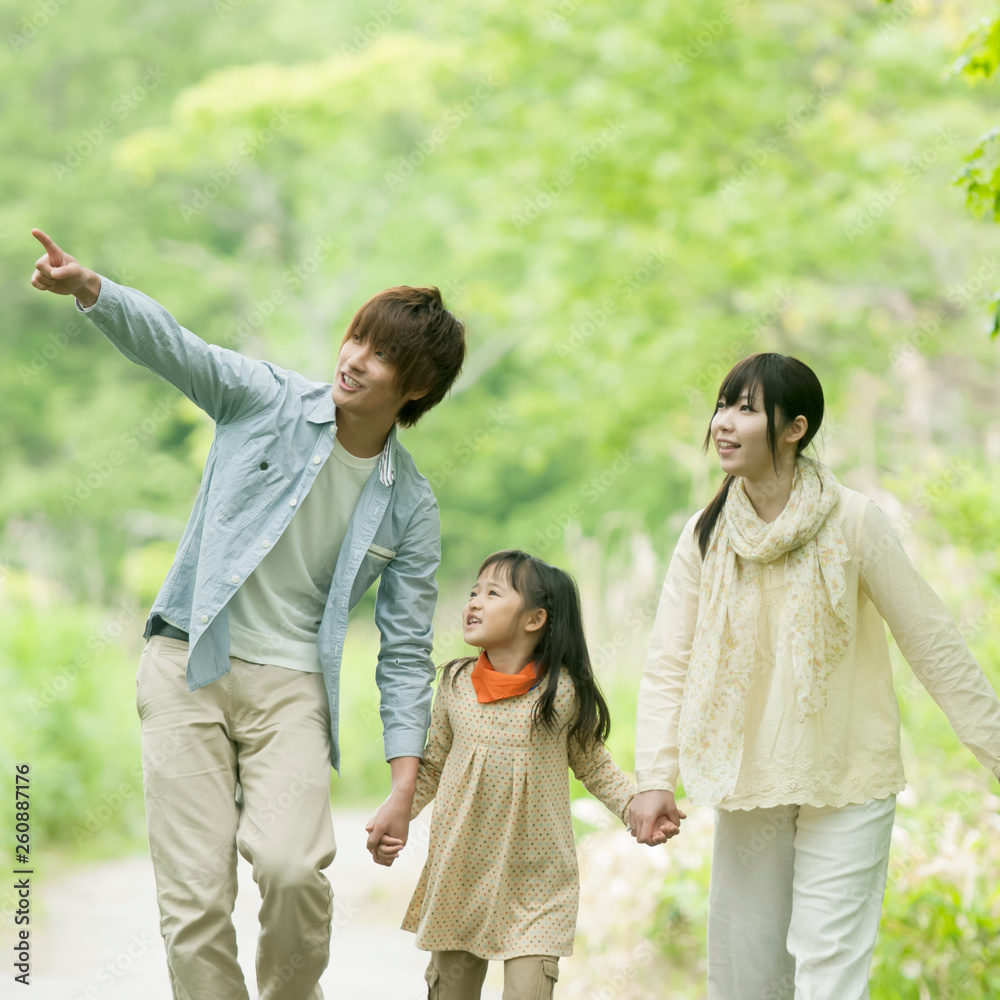 新緑の中で手をつなぐ家族