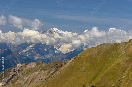Hiking in Aosta valley, Italy. View of Mont Blanc Massif with cloudy sky. Telephoto from Mount Creya (Cogne valley).