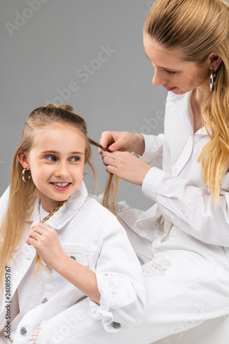 Excited young lady in white jacket talking to her elder sister