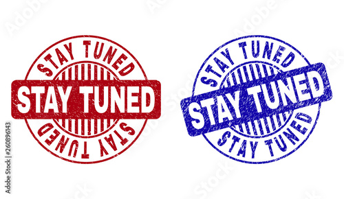 Grunge STAY TUNED round stamp seals isolated on a white background. Round seals with grunge texture in red and blue colors. Vector rubber imprint of STAY TUNED caption inside circle form with stripes.