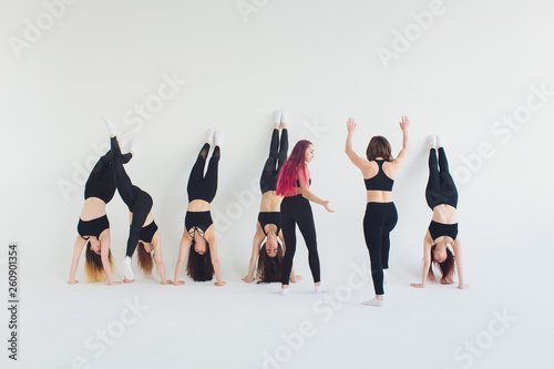 Fitness, stretching workout, attractive mature woman in violet sportswear working out in sports club, keeping fit, doing shoulderstand exercise, Viparita Karani, Upside-Down Seal pose in class.