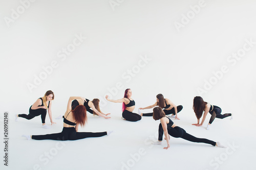 Fitness, stretching practice, group of two attractive happy smiling fit mature women working out in sports club, doing Extended Side Angle posture, utthita parshvakonasana pose in class, full length. photo