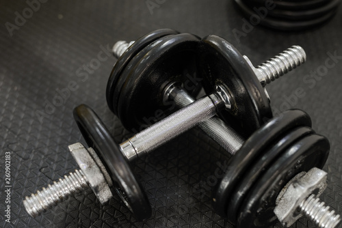 Iron dumbbells or weights on black floor in the gym. Weight Training Equipment. Health care concept.