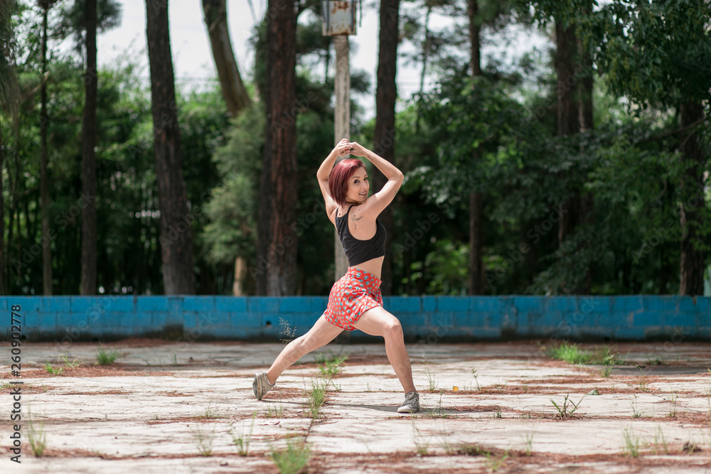 Happy redhead smiling girl dancing in a green park on Brazil in a summer day Happy redhead smiling girl dancing in a green park on Brazil in a summer day